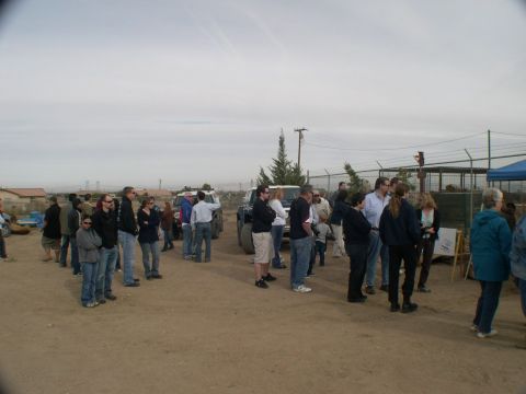 2007 Toyota FJ Cruiser - A group of people stand around a white Toyota FJ Cruiser and another SUV in an outdoor, dusty area.