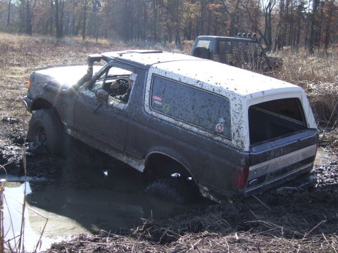 1979 Ford Bronco - This SUV is stuck in the mud, with another vehicle visible in the background.