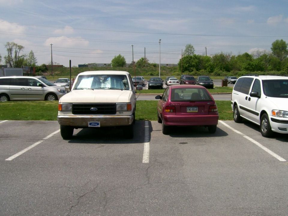 White 1987 Ford F-Series truck parked in a lot with other vehicles