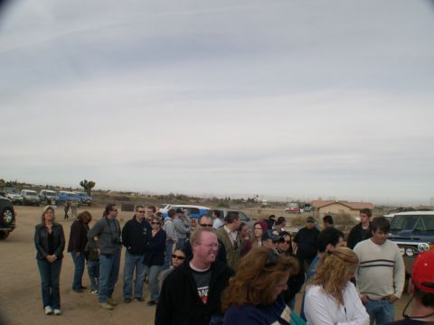 2007 Toyota FJ Cruiser - A group of people stand around multiple vehicles in a desert landscape under an overcast sky.