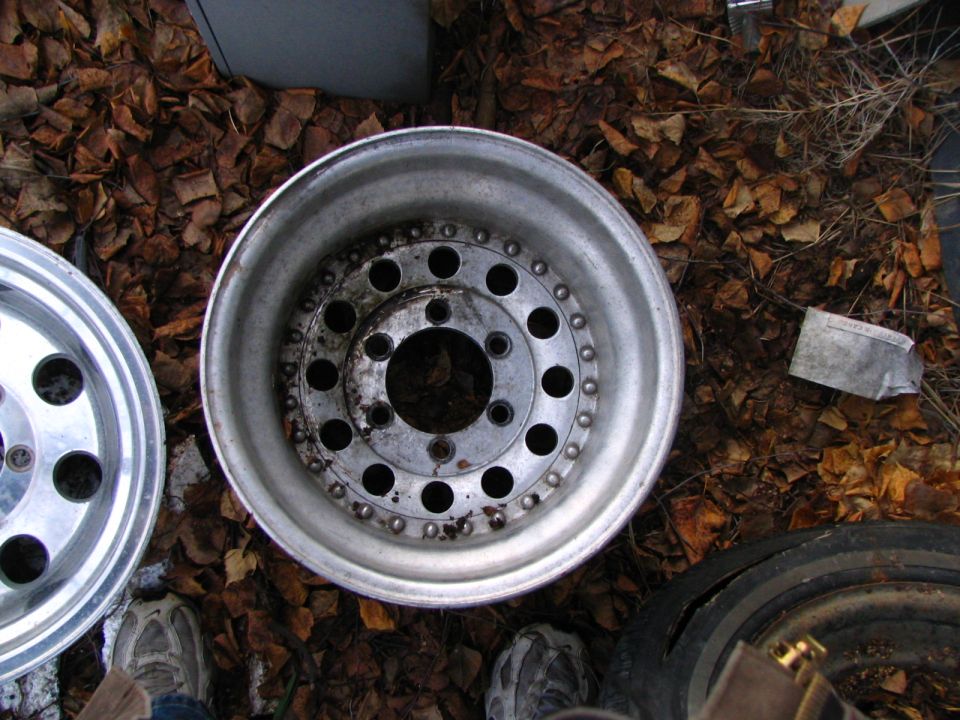 Two aluminum alloy wheels on a bed of fallen leaves
