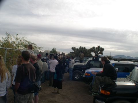 2007 Toyota FJ Cruiser - A group of people gather around several Toyota FJ Cruisers in a desert setting, possibly during an off-road event.