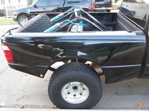 2007 Ford Ranger - A modified black Ford Ranger pickup truck bed is shown from the rear, with a spare tire and off-road suspension components.