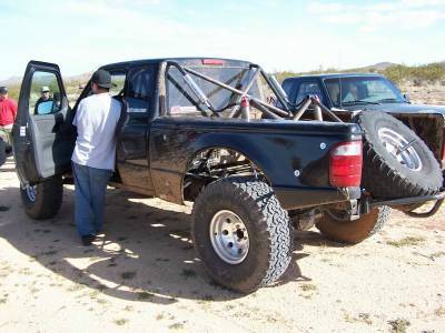 2007 Ford Ranger - A modified black 2007 Ford Ranger pickup truck is parked outdoors with its driver's door open.
