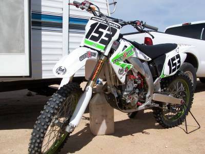 2007 Ford Ranger - Motocross dirt bike with number 153 on front and side, parked next to a trailer and truck.