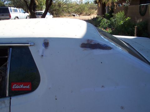 1972 Ford Ranchero - A white car with visible rust damage on its roof and an aftermarket sticker on the window.