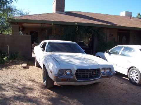 1972 Ford Ranchero - A white 1972 Ford Gran Torino is parked in front of a house, with another white car to its right.