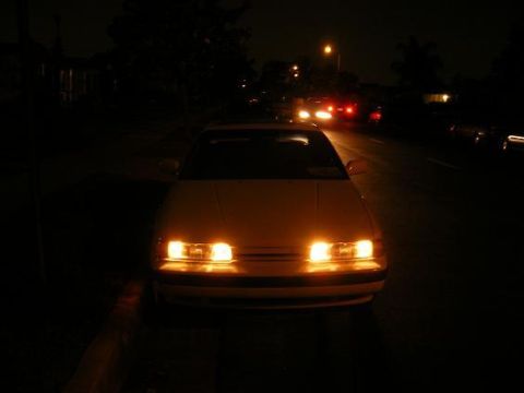 1991 Mazda MX-6 - Front view of a 1991 Mazda MX-6 at night, headlights illuminated.