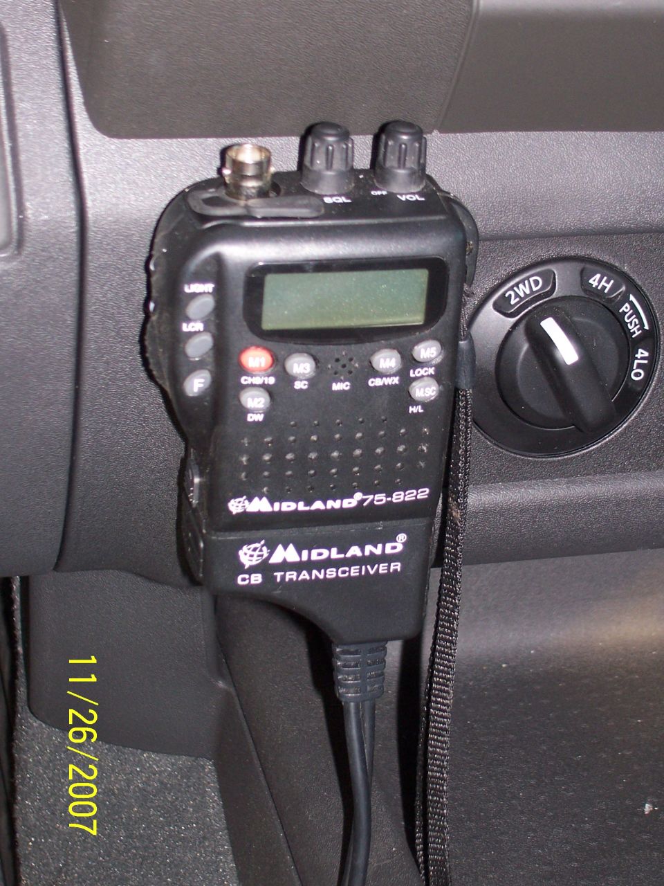 Black Midland 75-822 CB radio mic mounted on dash next to 2WD/4H/4LO selector knob