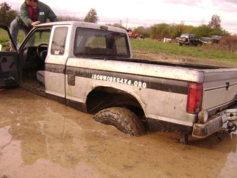 1990 Ford Ranger - A person is trying to get a pickup truck unstuck from a muddy field.
