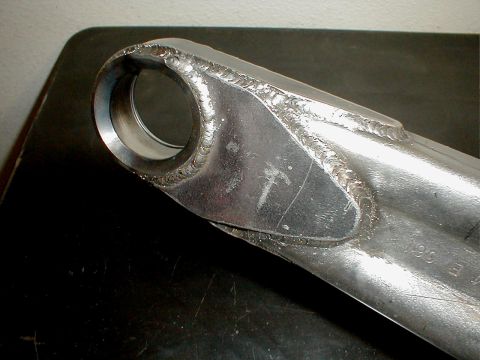 1996 Ford Bronco - A close-up view of a metal part, likely from a vehicle's suspension system, showing extensive welding.