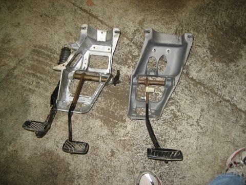 1990 Ford Bronco - Two pedal assemblies, likely for an automatic to manual transmission swap, are shown laid out on a concrete floor.