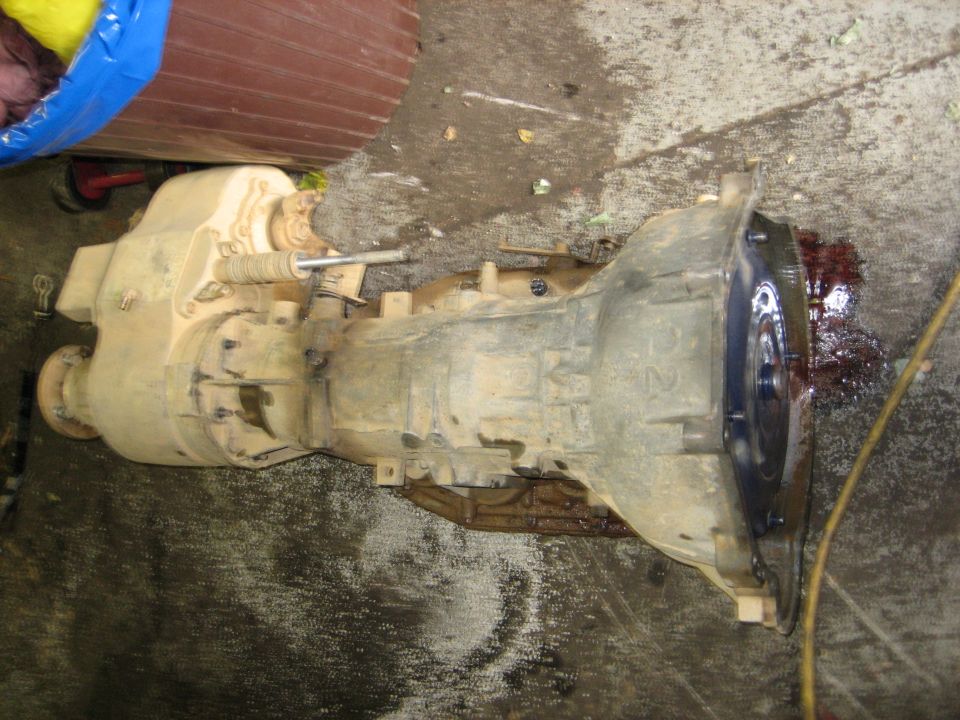 Dirty transmission and transfer case assembly on concrete floor