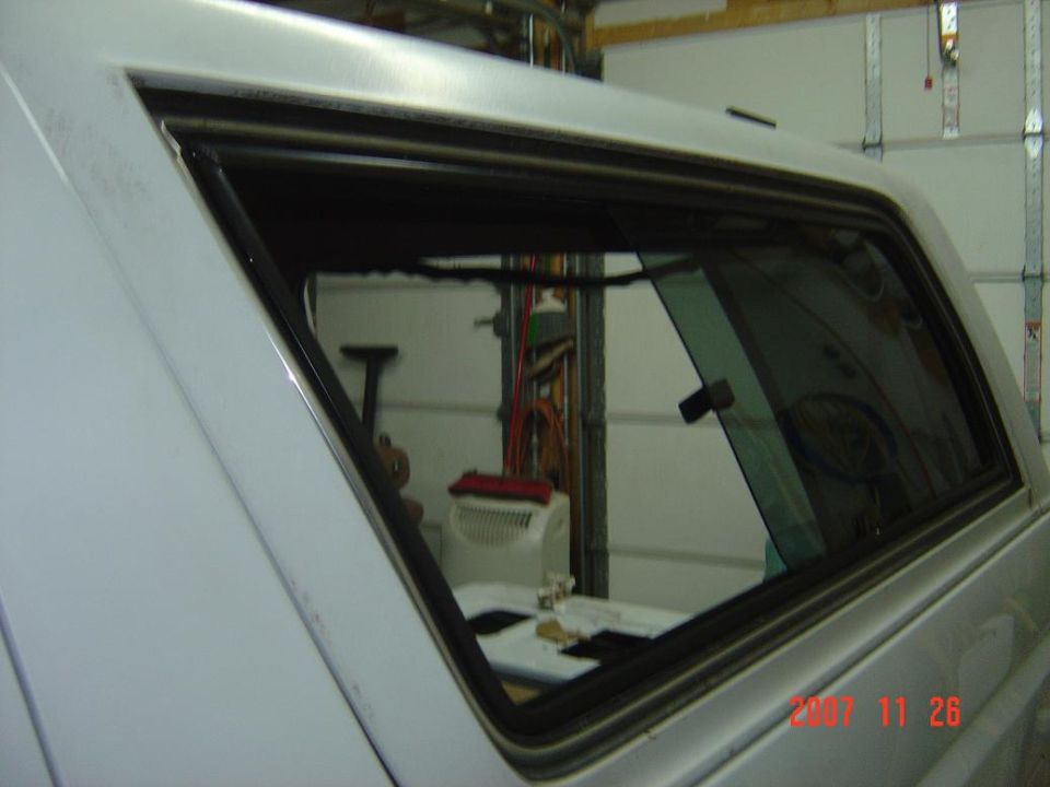Rear quarter window opening of a truck cap or canopy in a garage
