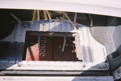 1991 Ford Bronco - Interior view of a vehicle's cargo area, revealing a metal panel and straps.