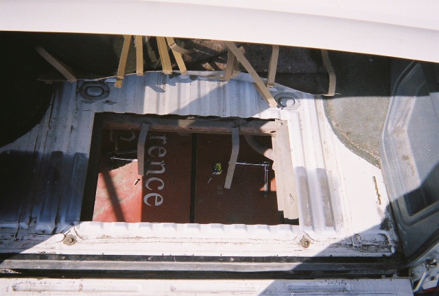 Vehicle cargo area showing a metal panel with straps and the word 'rence' visible