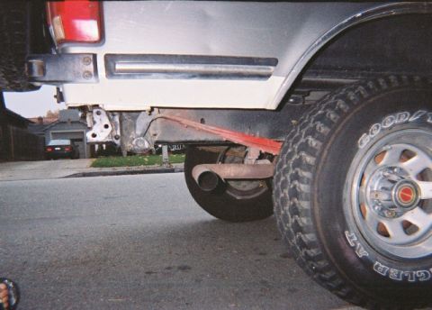 1991 Ford Bronco - Close-up of the rear suspension and axle of a 1991 Ford Bronco, with a red strap visible.