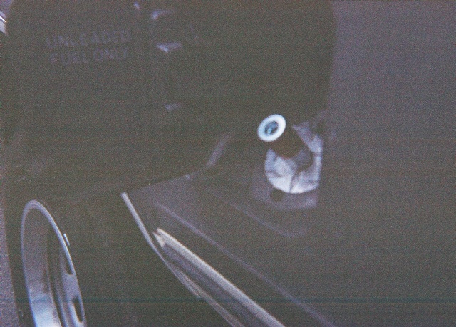 Dark vehicle fuel filler door with unleaded fuel only text