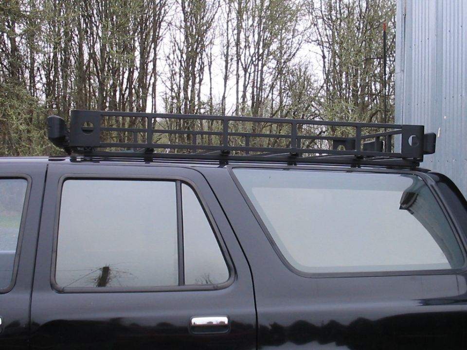 Black SUV side view with roof rack and Supermotors watermark