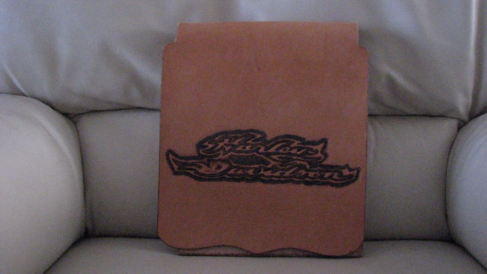 Leather item embroidered with a Harley-Davidson logo on a light couch