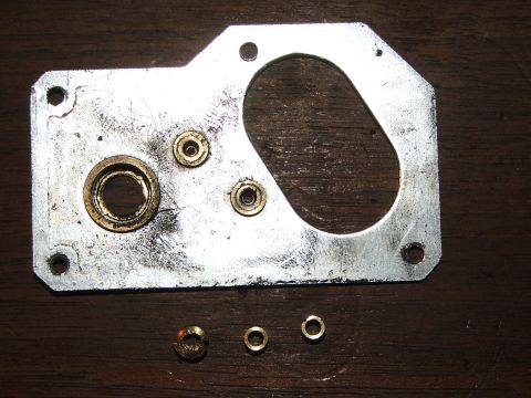 1996 Ford Bronco - A metal plate with various fittings and small rings, likely a mechanical component.