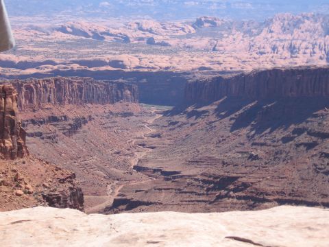 1979 Ford Bronco - A vast canyon vista unfolds with a winding road carved into the terrain, dramatic geological formations.