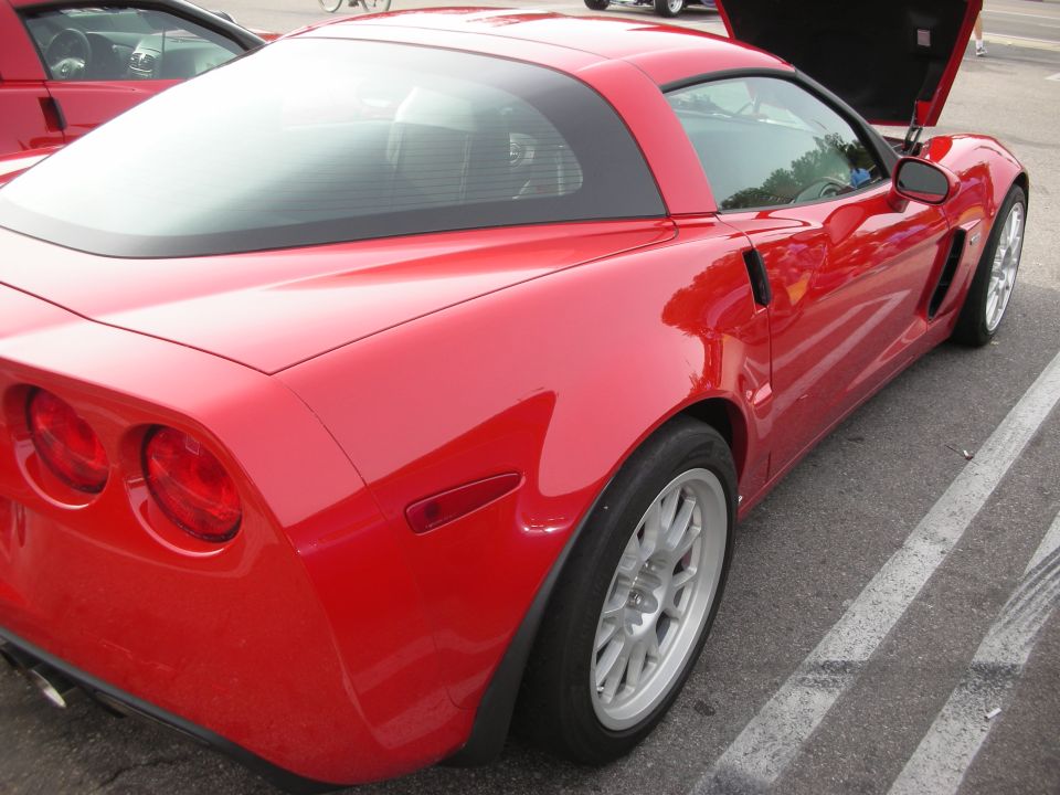 Rear three-quarter of a red Corvette Z06 coupe in a parking lot