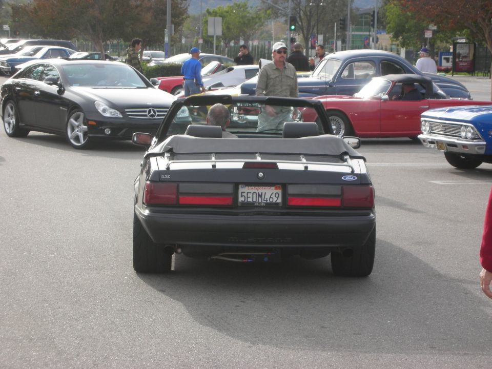 Rear of a black Fox-body Ford Mustang convertible at a car show
