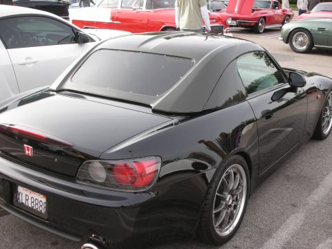 1998 Ford Crown Victoria - black Honda S2000 roadster fitted with a hardtop, shown from the rear three-quarter among cars at a show.