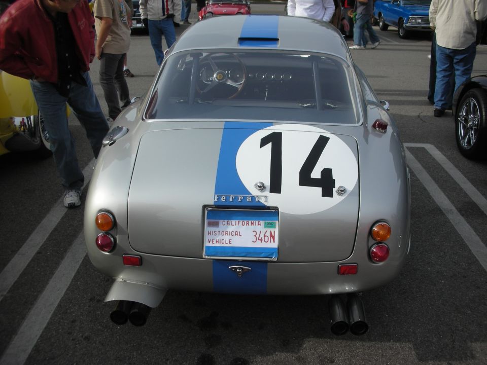 Rear of a silver coupe with blue racing stripe and number 14 roundel at a car show
