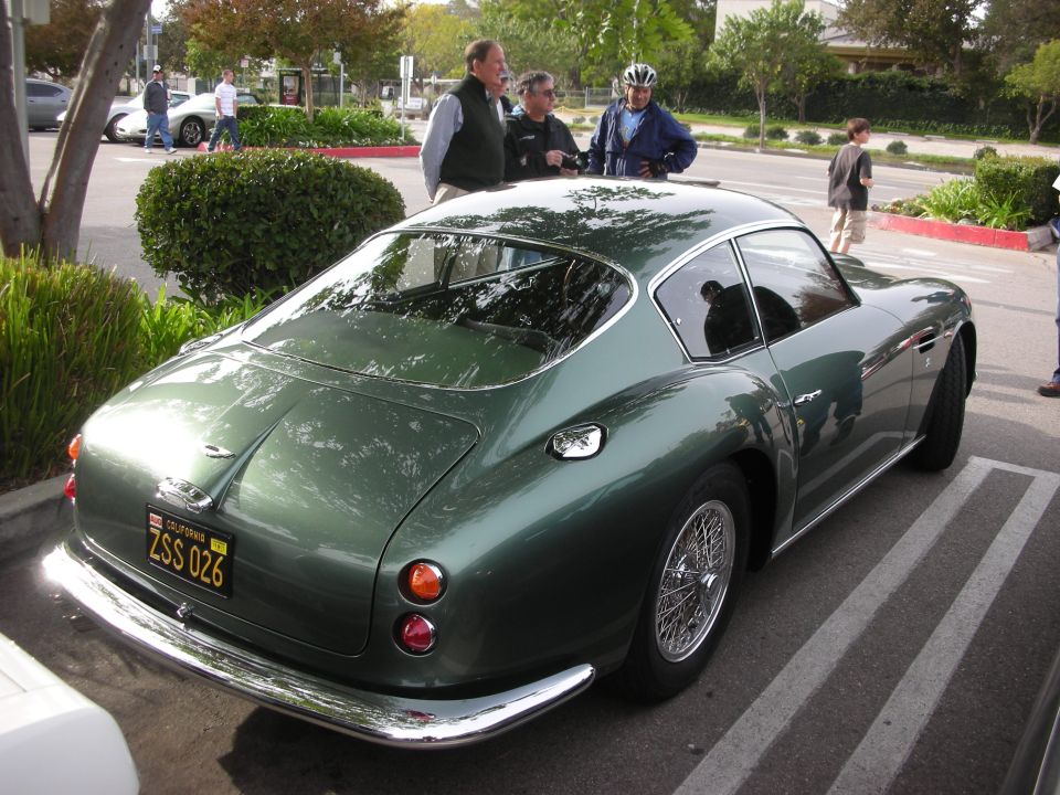 Rear of a green vintage Aston Martin fastback with wire wheels at a car show