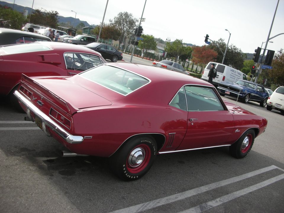 Rear three-quarter of a magenta 1969 Chevrolet Camaro coupe at a car show