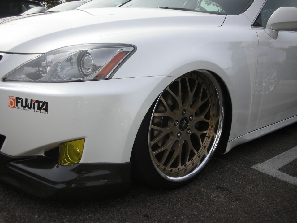 Front fender and bronze mesh wheel of a white lowered Lexus IS sedan