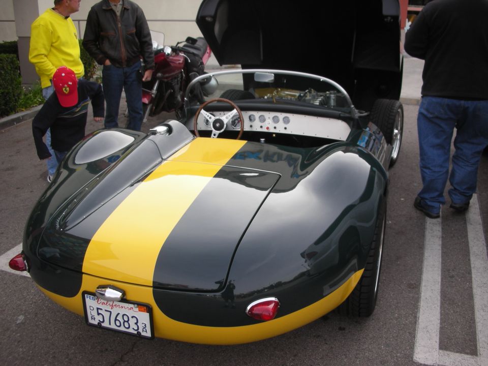 Rear of a green and yellow vintage open-cockpit roadster with California plate