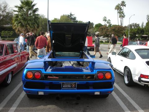 1998 Ford Crown Victoria - blue Lamborghini Diablo SV shown from the rear with its engine cover open, beside a classic Porsche 911 at a meet.