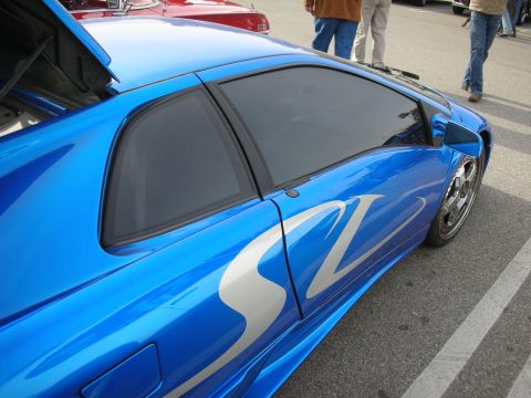 1998 Ford Crown Victoria - Side profile detail of a blue Lamborghini Diablo SV showing the door, side intake and silver SV graphic.