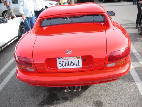 1998 Ford Crown Victoria - Rear view of a red Dodge Viper coupe with center exhaust and a California license plate, parked at a meet.