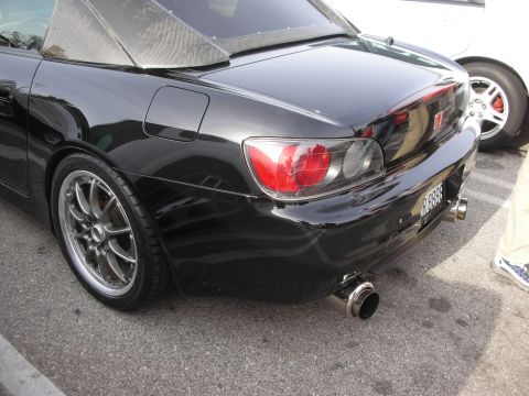 1998 Ford Crown Victoria - Rear three-quarter view of a black Honda S2000 with bronze aftermarket wheels and a polished exhaust tip.