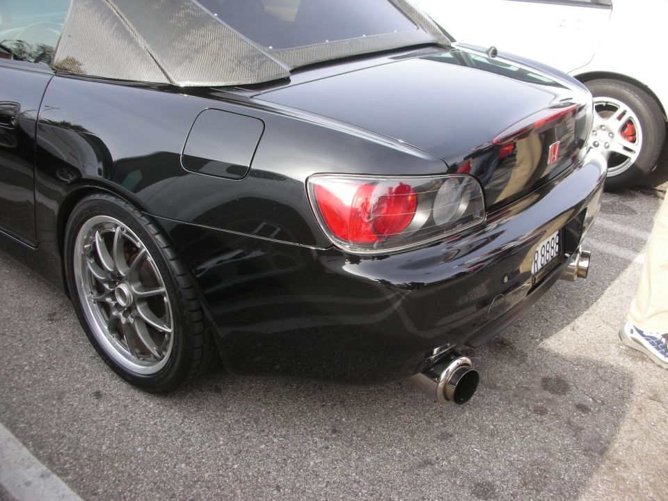 Rear quarter of a black Honda S2000 with aftermarket wheels and exhaust