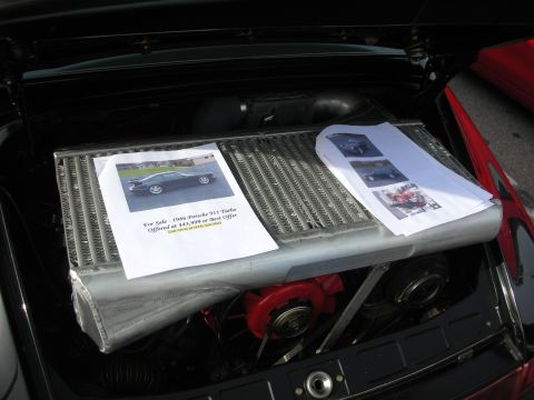 1998 Ford Crown Victoria - Open Porsche 911 engine bay topped by a for-sale flyer reading 1986 Porsche 911 Turbo offered at $43,999 or best offer.
