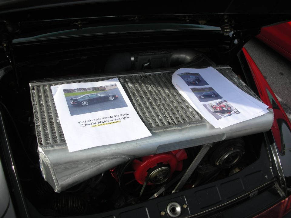 Porsche 911 Turbo engine bay with a printed for-sale flyer on top