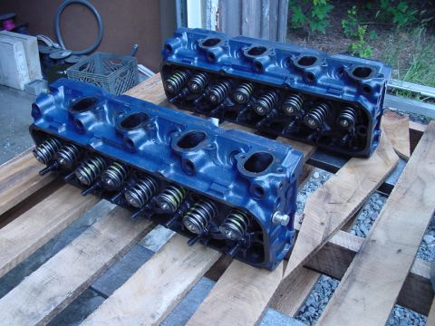 1979 Ford Bronco - A pair of engine cylinder heads, painted blue, are displayed on wooden pallets.