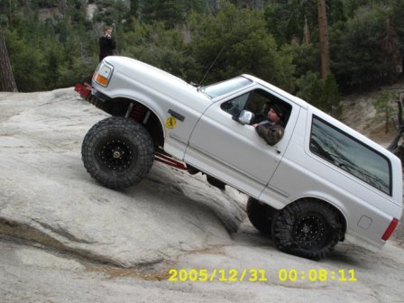 1996 Ford Bronco - White Ford Bronco navigating a challenging rocky terrain.