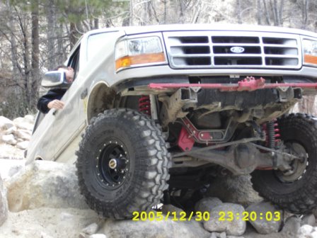 1996 Ford Bronco - A 1996 Ford Bronco navigates a rocky terrain, its lifted suspension and off-road tires.