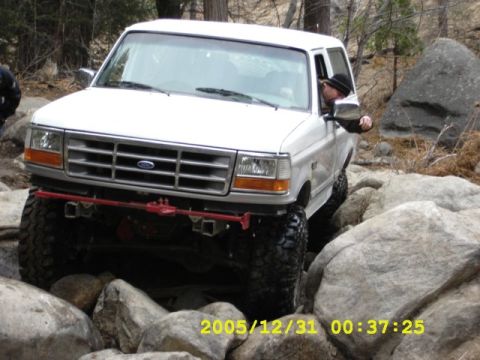 1996 Ford Bronco - White 1996 Ford Bronco tackles a challenging off-road course with large boulders.