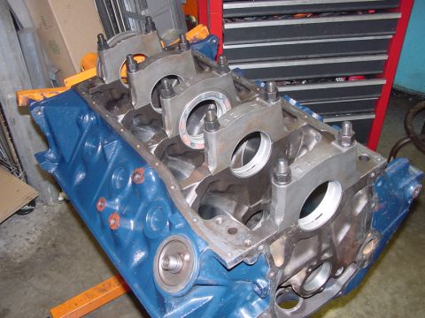 1979 Ford Bronco - An engine block is shown disassembled on an engine stand, with main bearing caps removed.