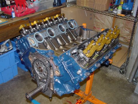 1979 Ford Bronco - V8 engine block assembly with timing chain and valve train components visible, mounted on an engine stand.