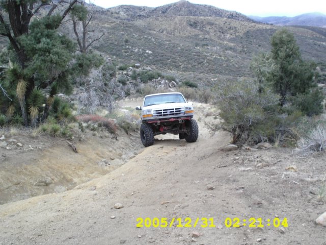 White 1996 Ford Bronco on a dirt trail, front view
