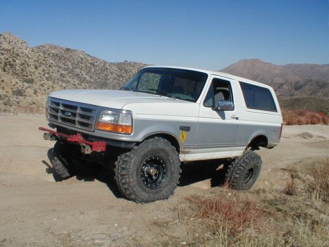 1996 Ford Bronco - This 1996 Ford Bronco is equipped with large off-road tires and appears to be navigating a challenging dirt path.