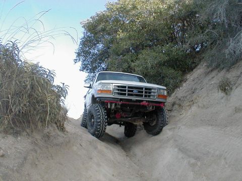 1996 Ford Bronco - This 1996 Ford Bronco navigates a challenging off-road trail, its lifted suspension and aggressive tires.